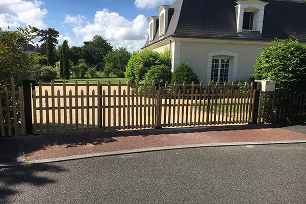 Palissade ajourée en châtaignier devant une maison